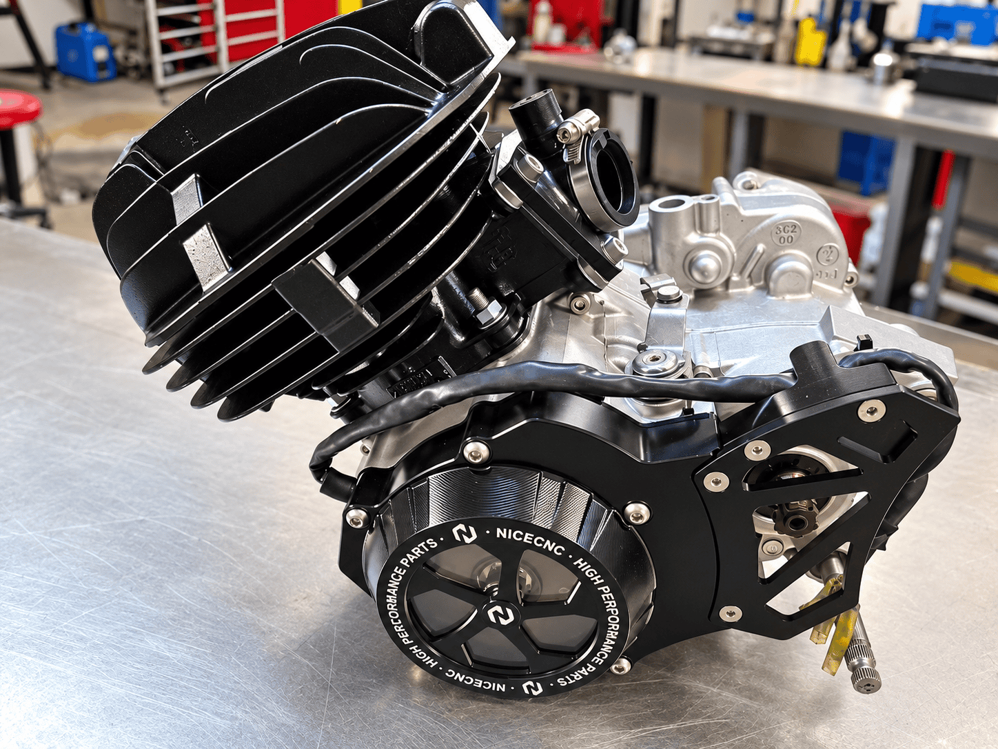 Rebuilt Yamaha Blaster engine with black finned cylinder, silver cases and black NICECNC covers on a shop bench