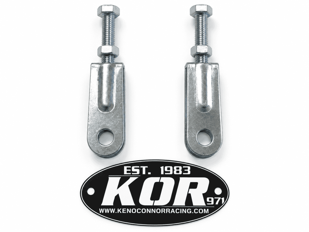 Two Yamaha Blaster chain adjusters with threaded bolts and nuts on a white background above the black and white KOR logo.