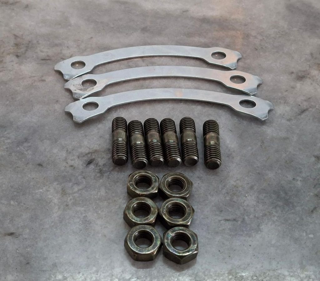 Racing hardware components including bolts, nuts, and brackets for car performance upgrades.