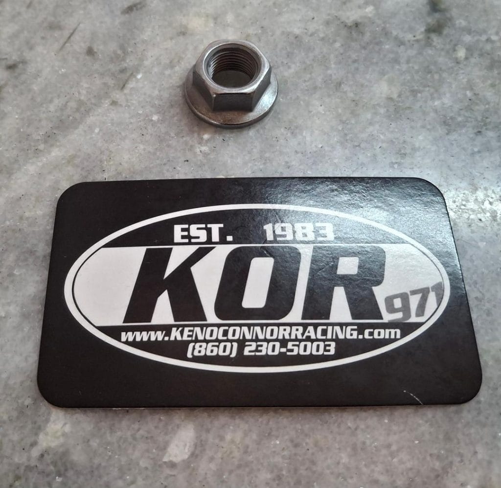 Keno O'Connor Racing logo with a nut on a concrete surface.
