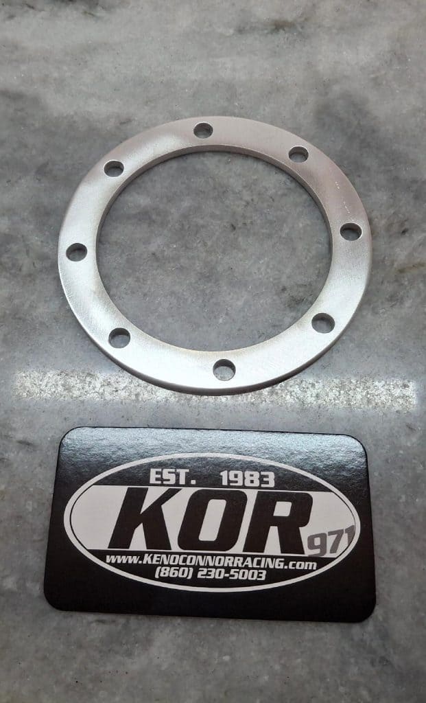 Wheel spacer for racing cars with multiple bolt holes, branded KOR Racing.